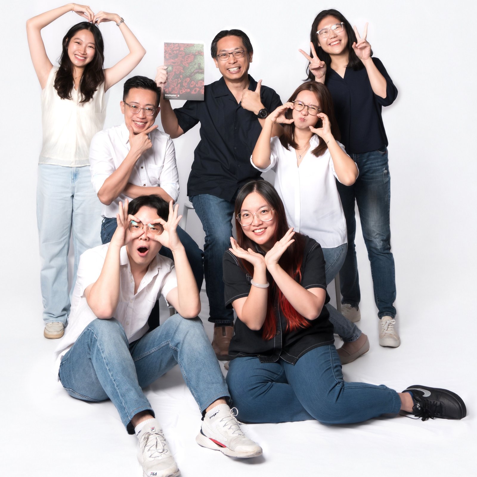 The team pulling faces and hand-heart poses in the studio